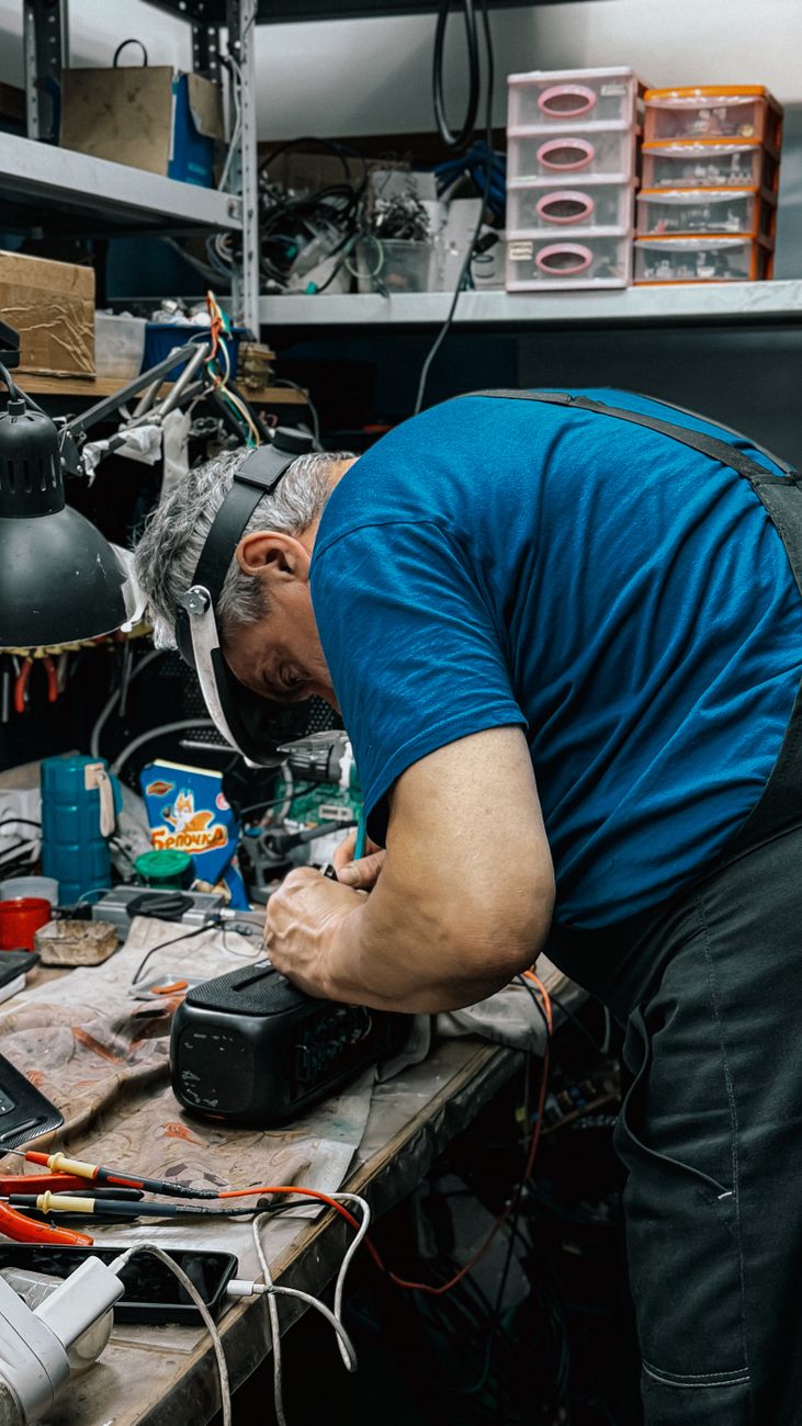 Founder Luis Harper standing in a tidy workshop beside cable reels and tools